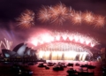 New Year's Eve fireworks erupt over Sydney's iconic Harbour Bridge and Opera House (L) during the fireworks show on January 1, 2022. (Photo by DAVID GRAY / AFP).
