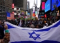 Supporters of Israel face people rallying in support of Palestinians in Times Square in New York on October 8, 2023 after the Palestinian militant group Hamas launched an attack on Israel. Israel, reeling from the deadliest attack on its territory in half a century, formally declared war on Hamas Sunday as the conflict's death toll surged close to 1,000 after the Palestinian militant group launched a massive surprise assault from Gaza. (Photo by Bryan R. Smith / AFP)/Reprodução DN.